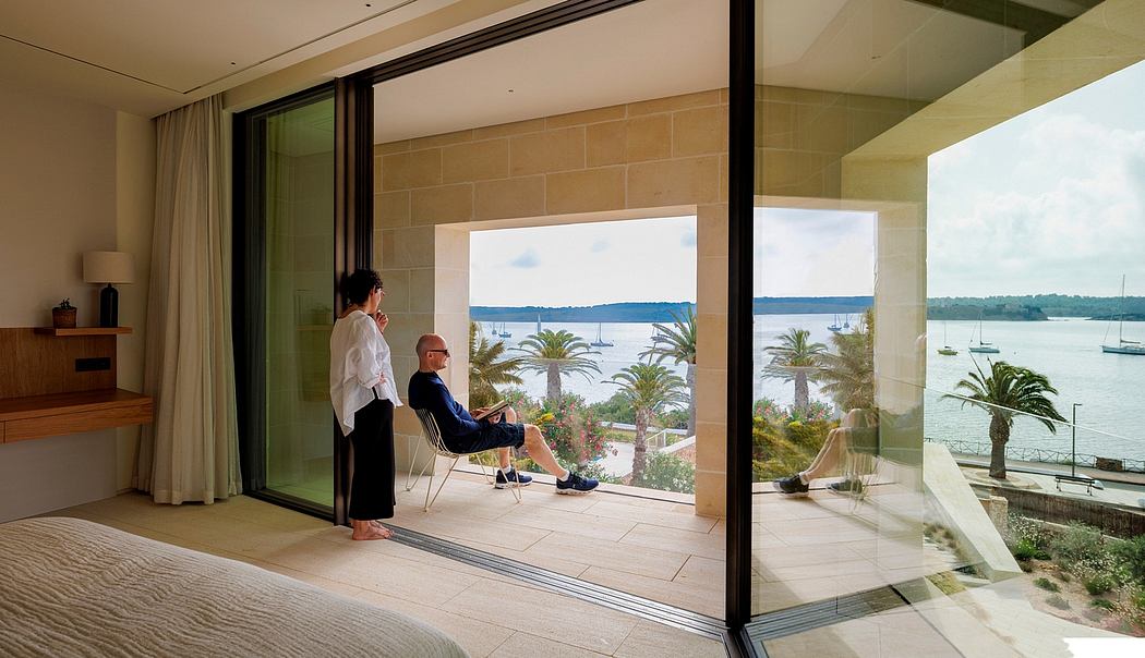 Spacious, airy room with large glass doors offering panoramic views of a coastal scene.