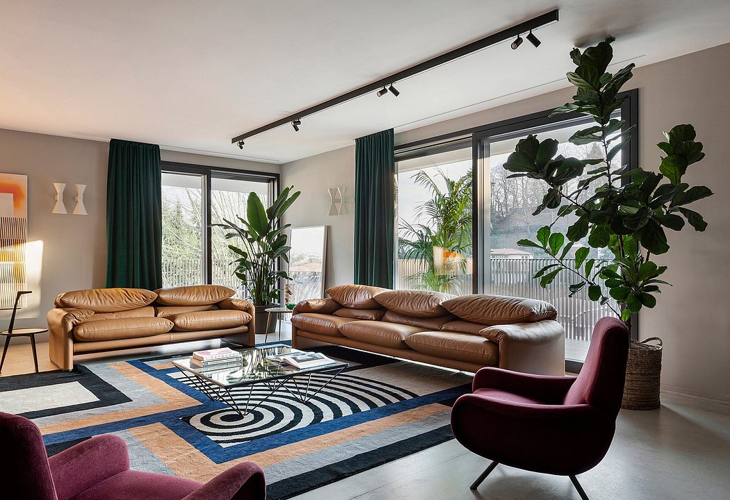 Chic living room with leather sofas, patterned rug, and lush indoor plants against large windows.