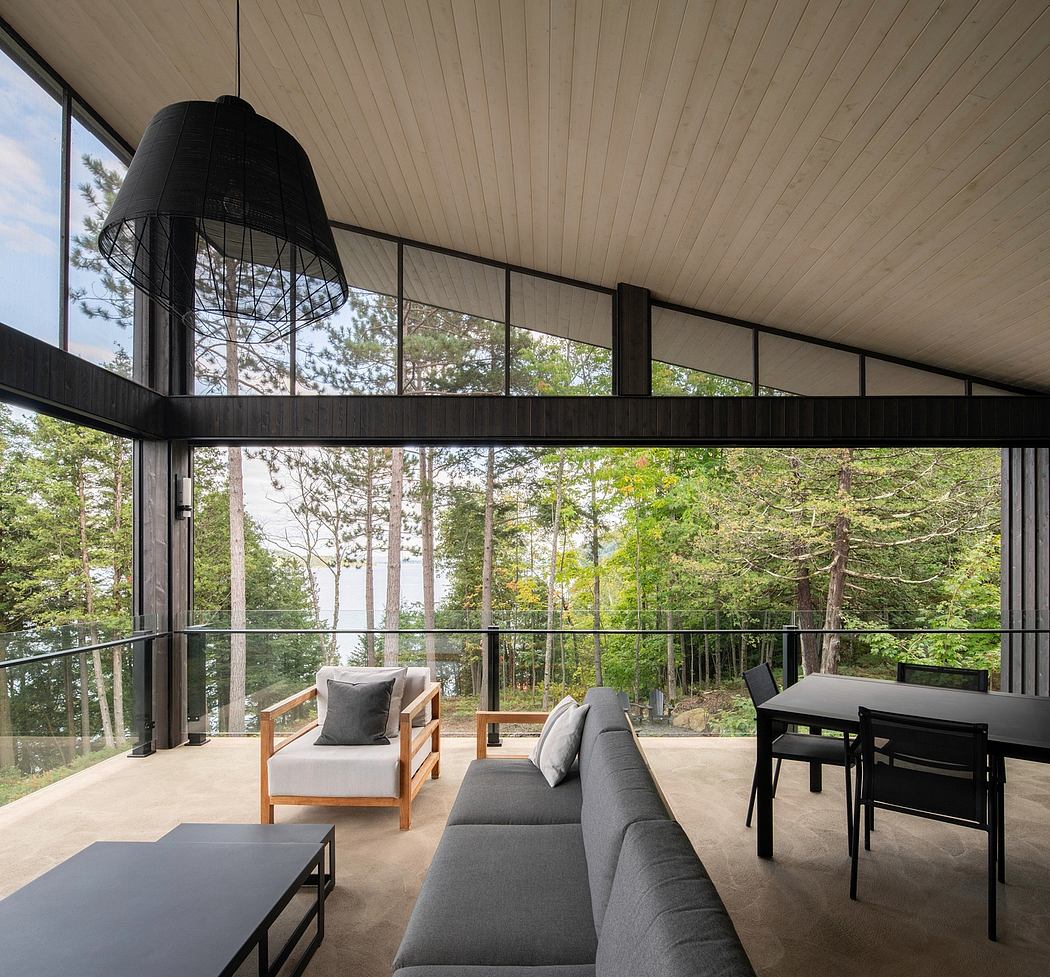 Large windows overlooking lush forest provide ample natural light in this modern, open-concept interior.