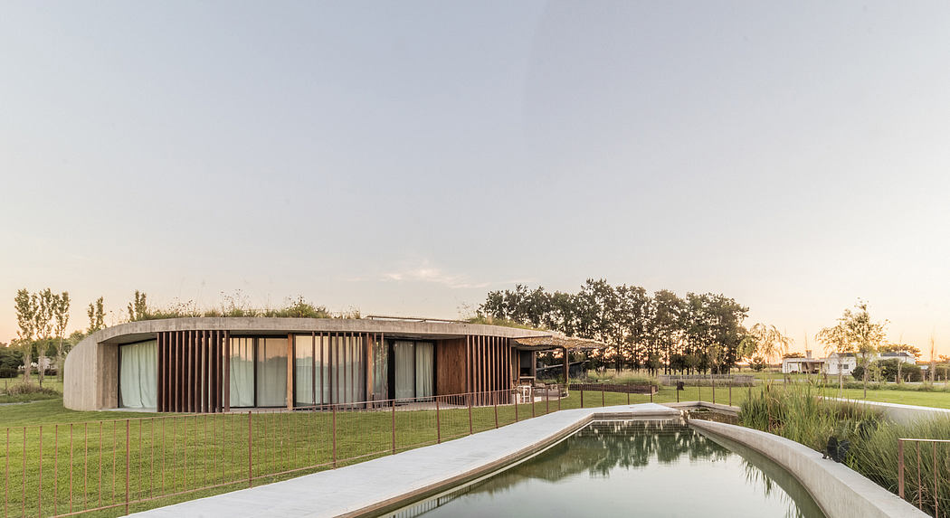Sleek, modern architecture with wooden slat facade overlooking a tranquil pond.