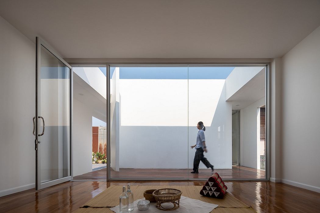 Minimalist interior design with large floor-to-ceiling windows, wooden flooring, and modern furniture.