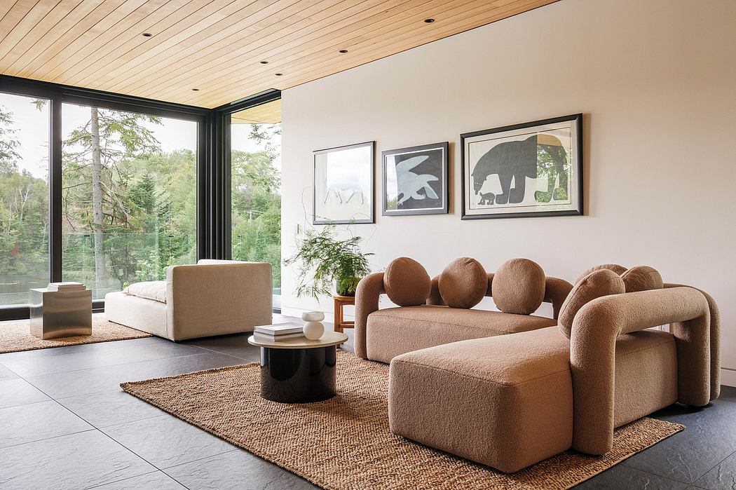Minimalist living room with wooden ceiling, large windows, and abstract artwork on the walls.