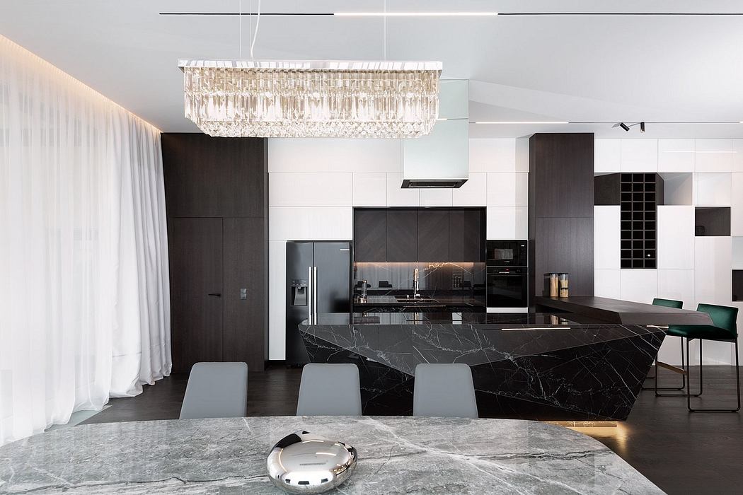 Sleek, high-contrast kitchen with stunning marble countertops, modern cabinetry, and a grand crystal chandelier.