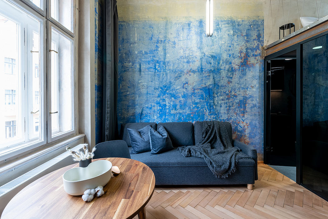 Bright living room with expansive windows, navy blue sofa, and abstract mural on the wall.