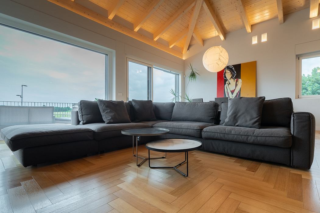 Spacious living room with wooden ceiling, large sectional sofa, and modern artwork.