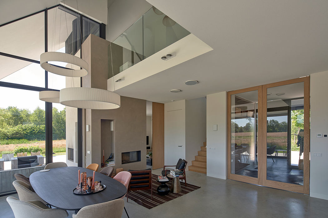 Spacious, modern living area with high ceilings, glass walls, and stylish lighting.