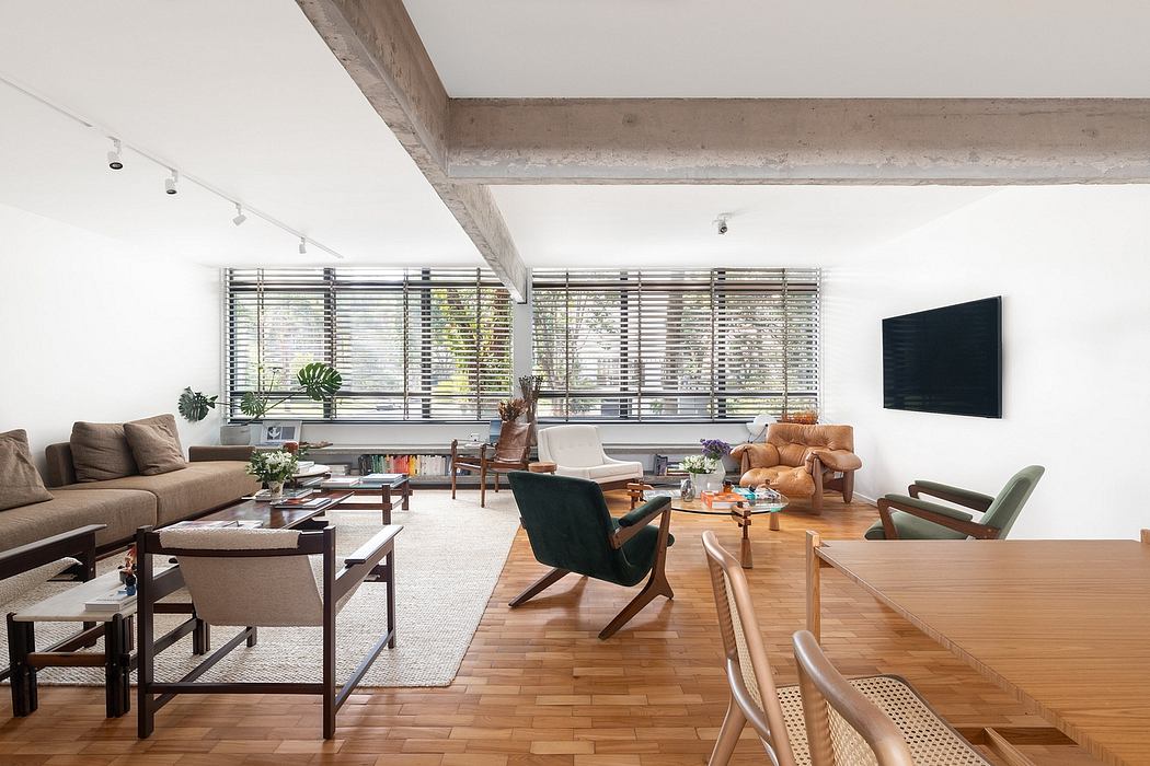 Spacious open-concept living room with concrete beams, wooden floors, and eclectic decor.