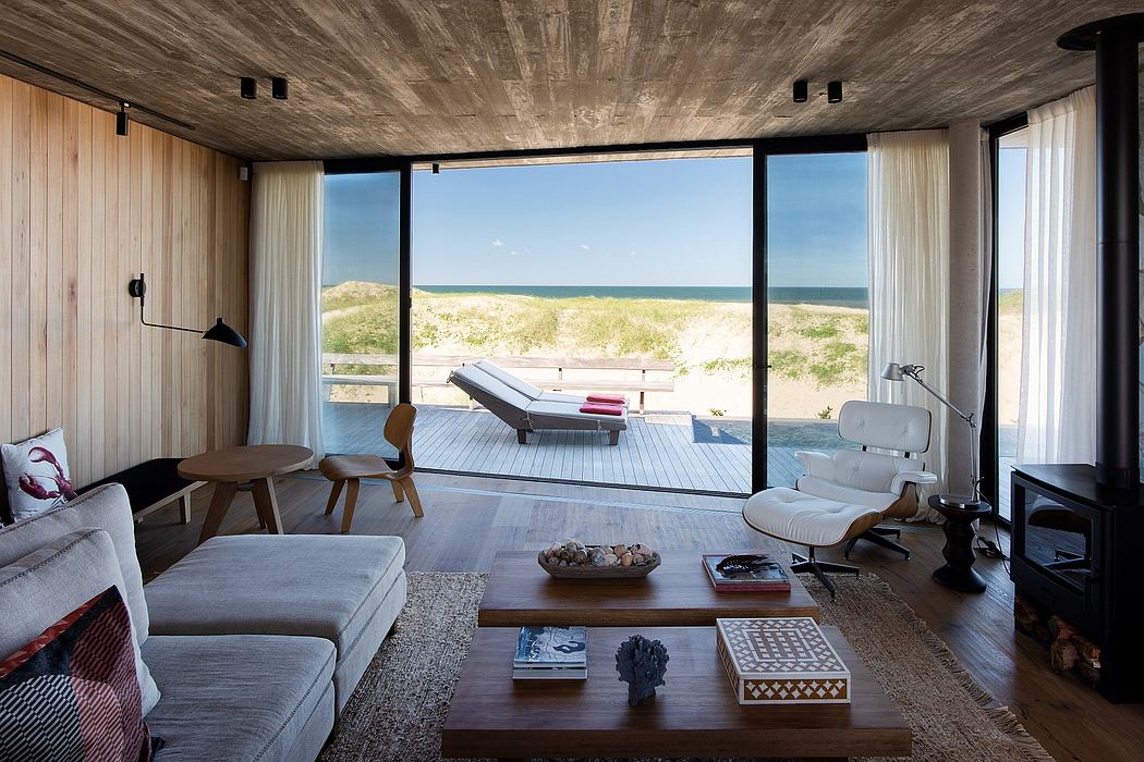 A modern, minimalist beach house interior with large windows showcasing a stunning ocean view.