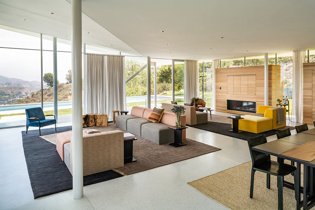 Large open-concept living space with floor-to-ceiling windows, modern furniture, and fireplace.