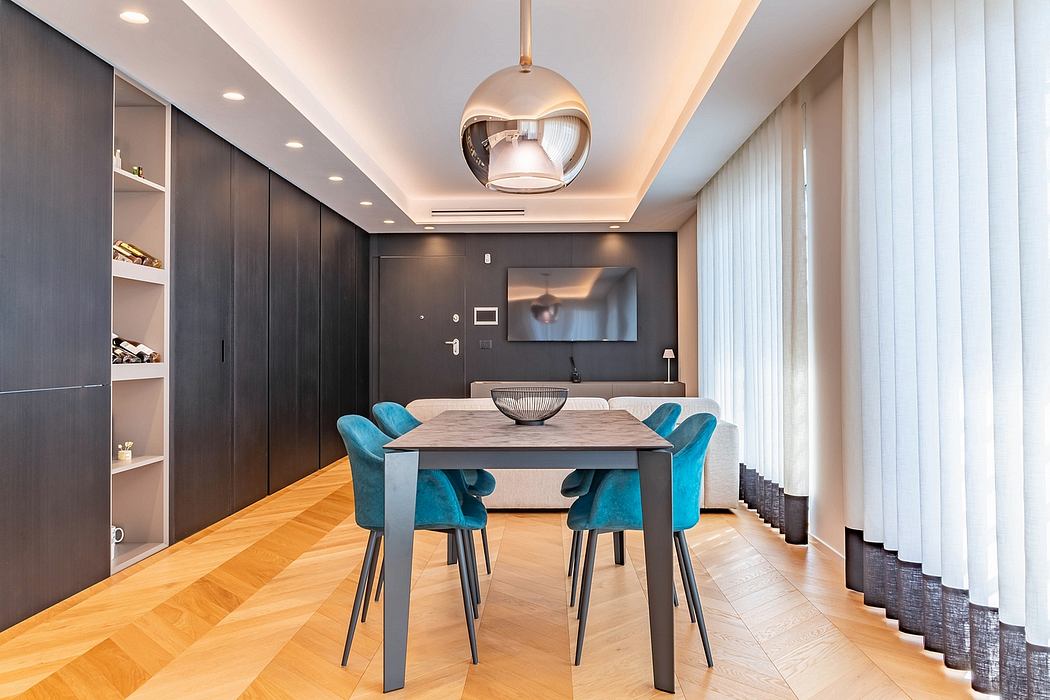 Modern dining room with gray walls, wood dining table, and teal chairs. Sleek chandelier and curtains.