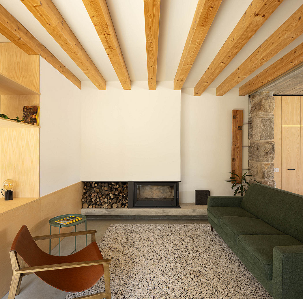 Warm, rustic interior with exposed wood beams, stone fireplace, and mid-century furniture.