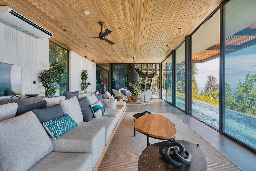 Spacious living room with floor-to-ceiling windows, wooden ceiling, and cozy furnishings.