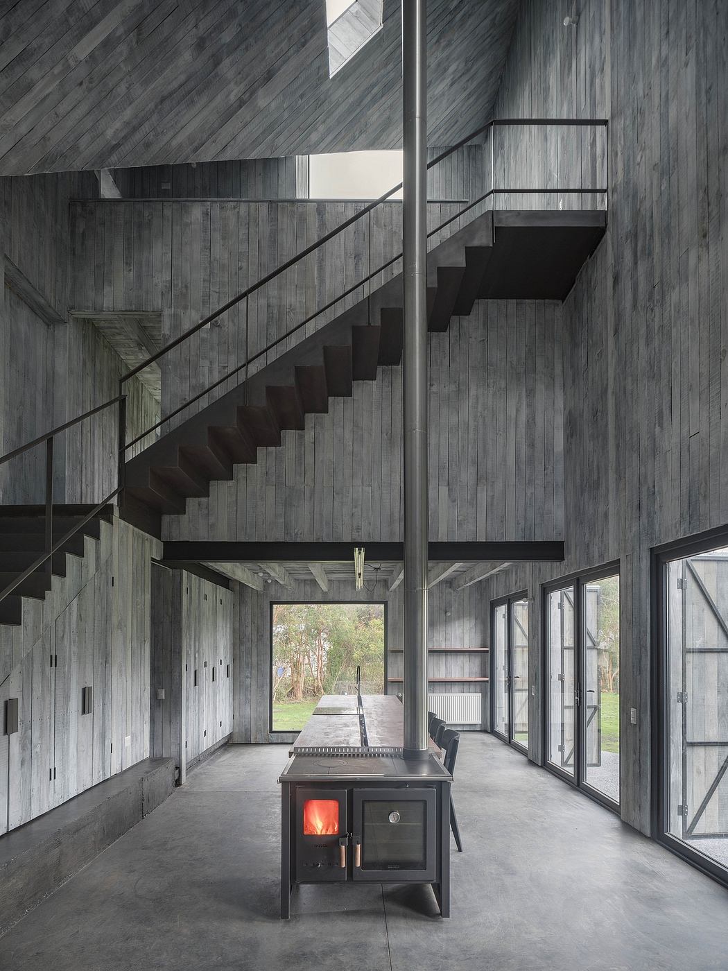 Striking modern design with concrete walls, sleek staircase, and large windows.