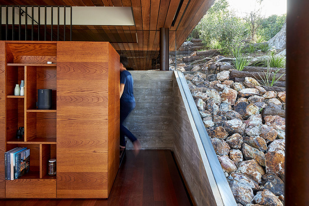 Wooden and concrete structure with shelving, leading to a rocky outdoor area.