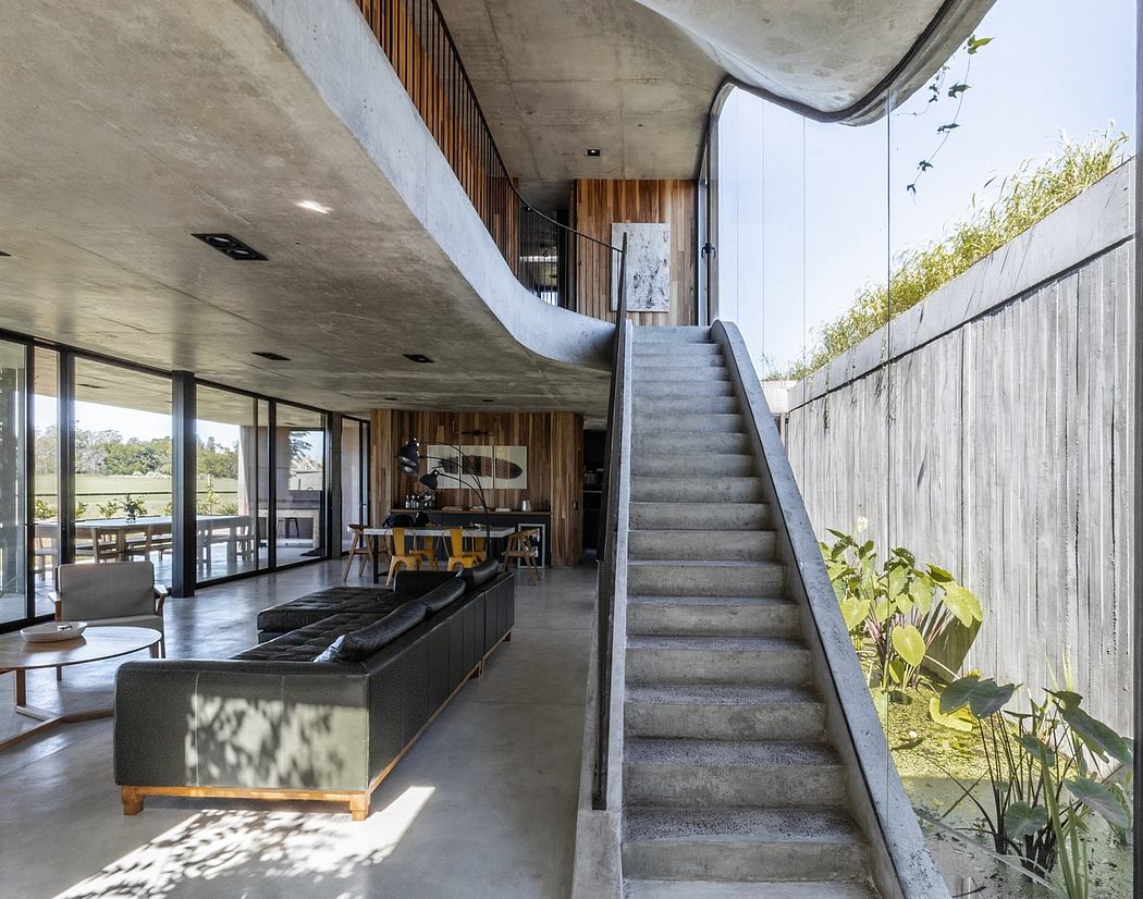 Striking concrete and wood interior with open-plan living and dramatic staircase.