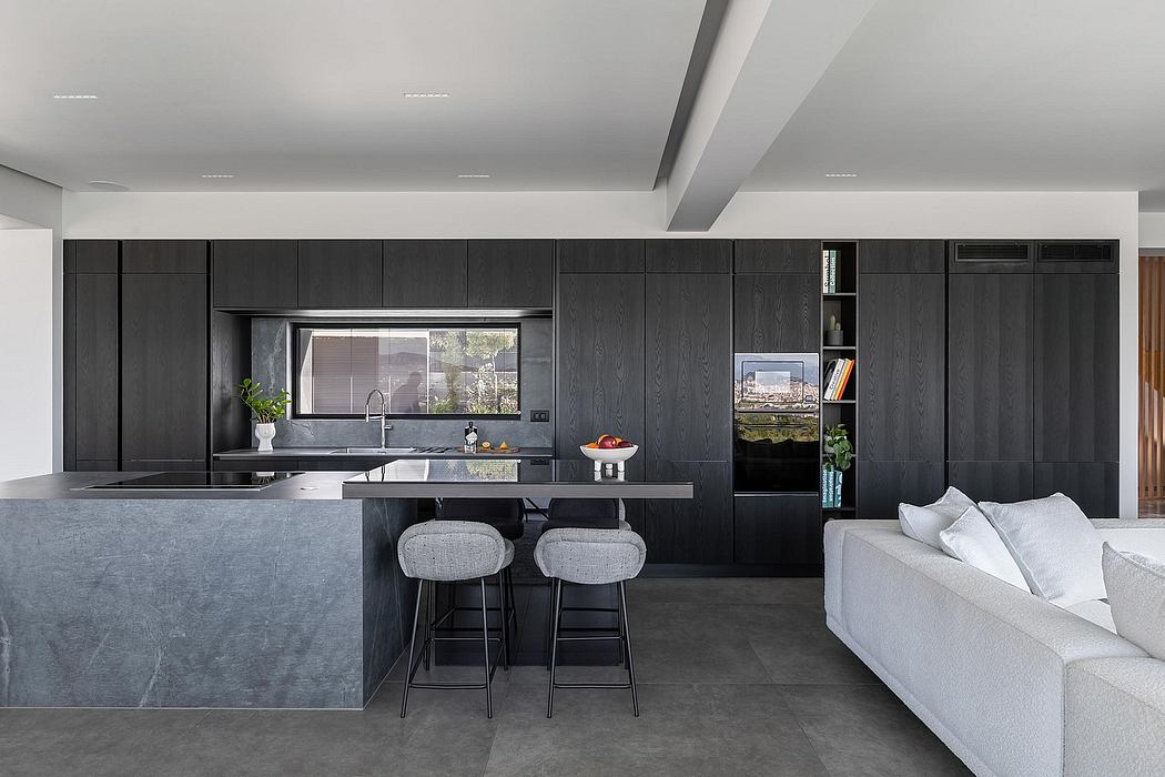 Sleek, modern kitchen with dark wood cabinets, large island, and view of outdoor landscape.