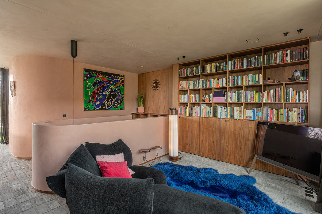 A cozy living space with floor-to-ceiling bookshelves, plush seating, and vibrant artwork.