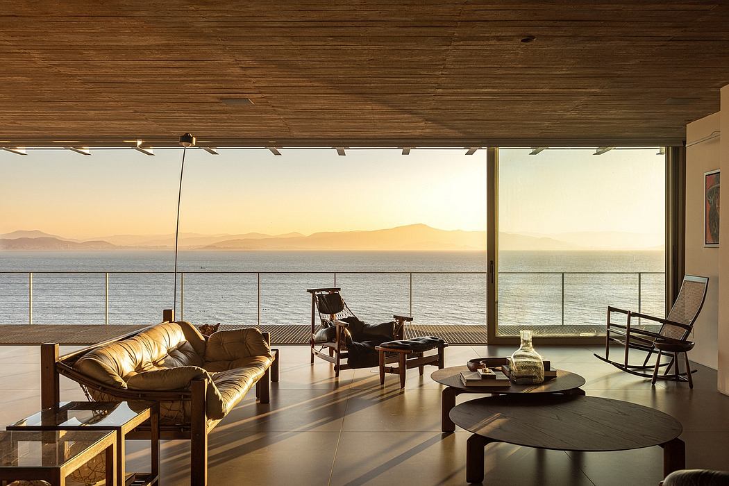 Spacious living room with panoramic ocean view, wooden ceiling, and stylish furnishings.
