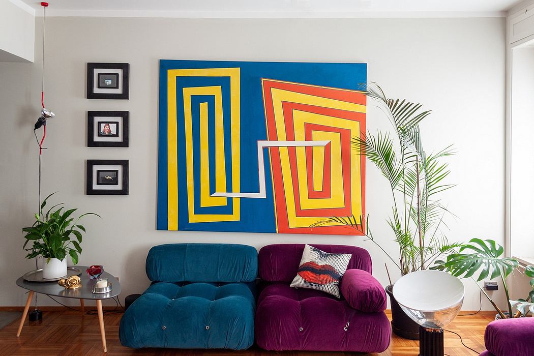 Vibrant geometric art, plush seating, and lush greenery create a dynamic, modern space.
