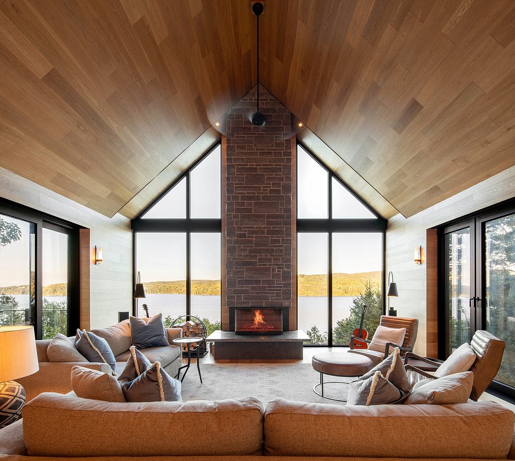 Spacious living room with vaulted wood ceiling, brick fireplace, and large windows offering scenic views.