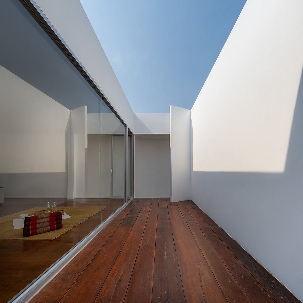 Minimalist architectural design with clean lines, wooden flooring, and sliding glass doors.