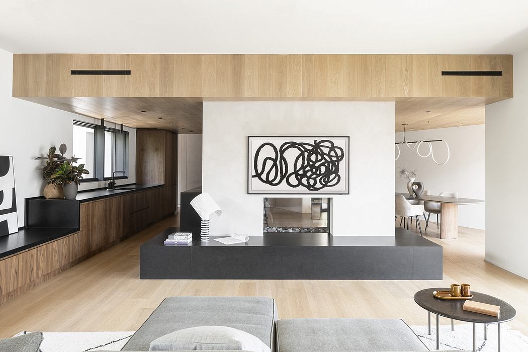 Modern open-concept living space with sleek wood paneling, black floating media unit, and minimalist artwork.