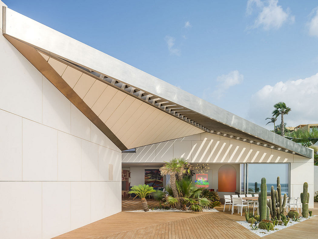 Modern architectural design with dramatic roof lines, lush landscaping, and an inviting outdoor seating area.