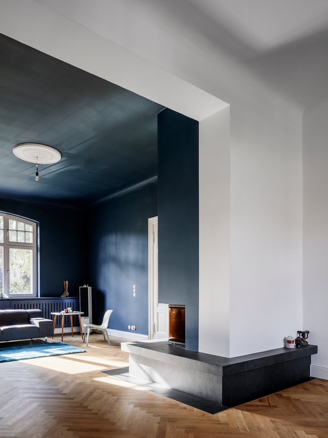 Dark walls, white trim, and sleek furniture create a modern, moody atmosphere.