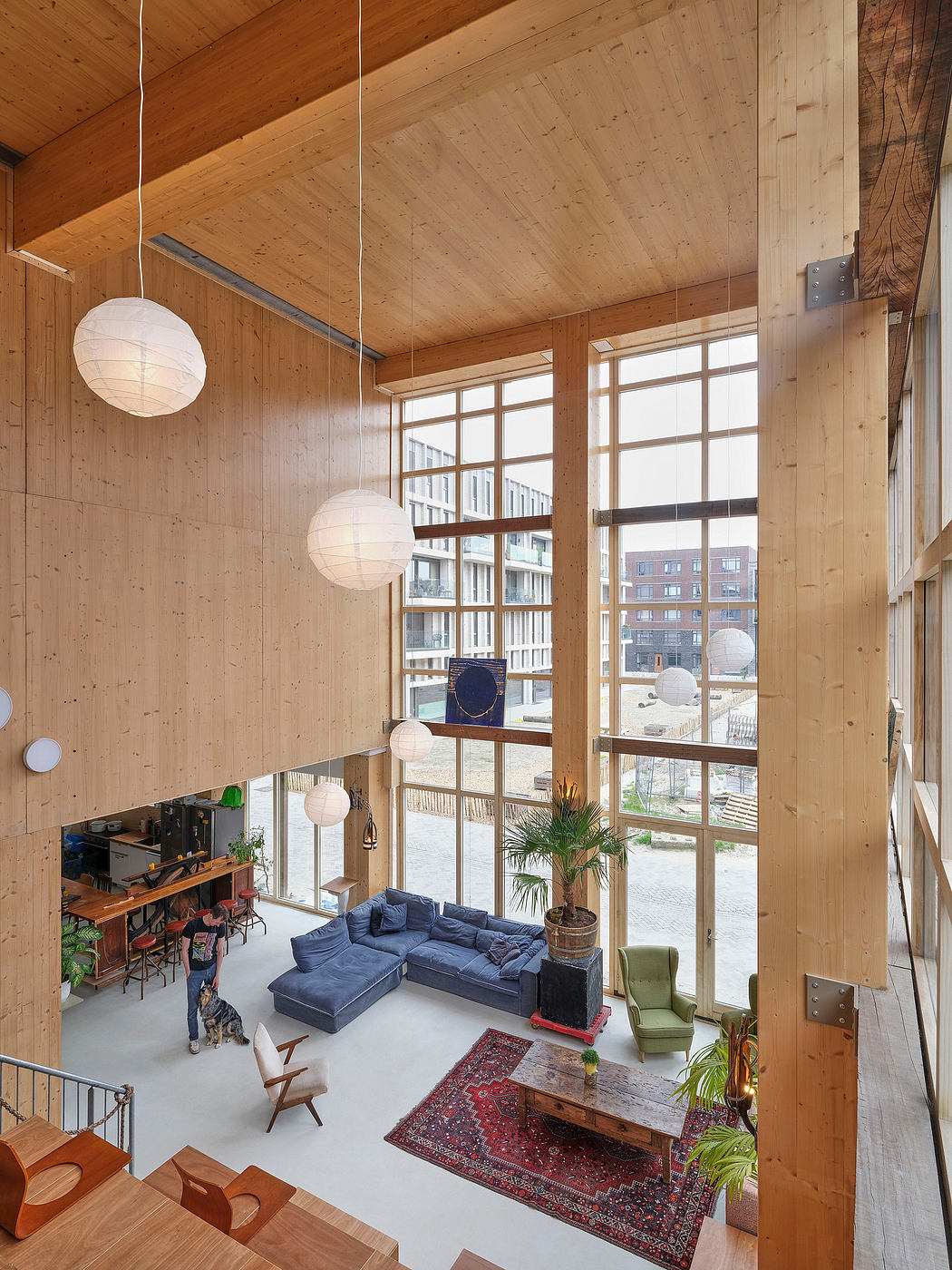 Spacious wood-paneled interior with large windows, modern furniture, and hanging lanterns.