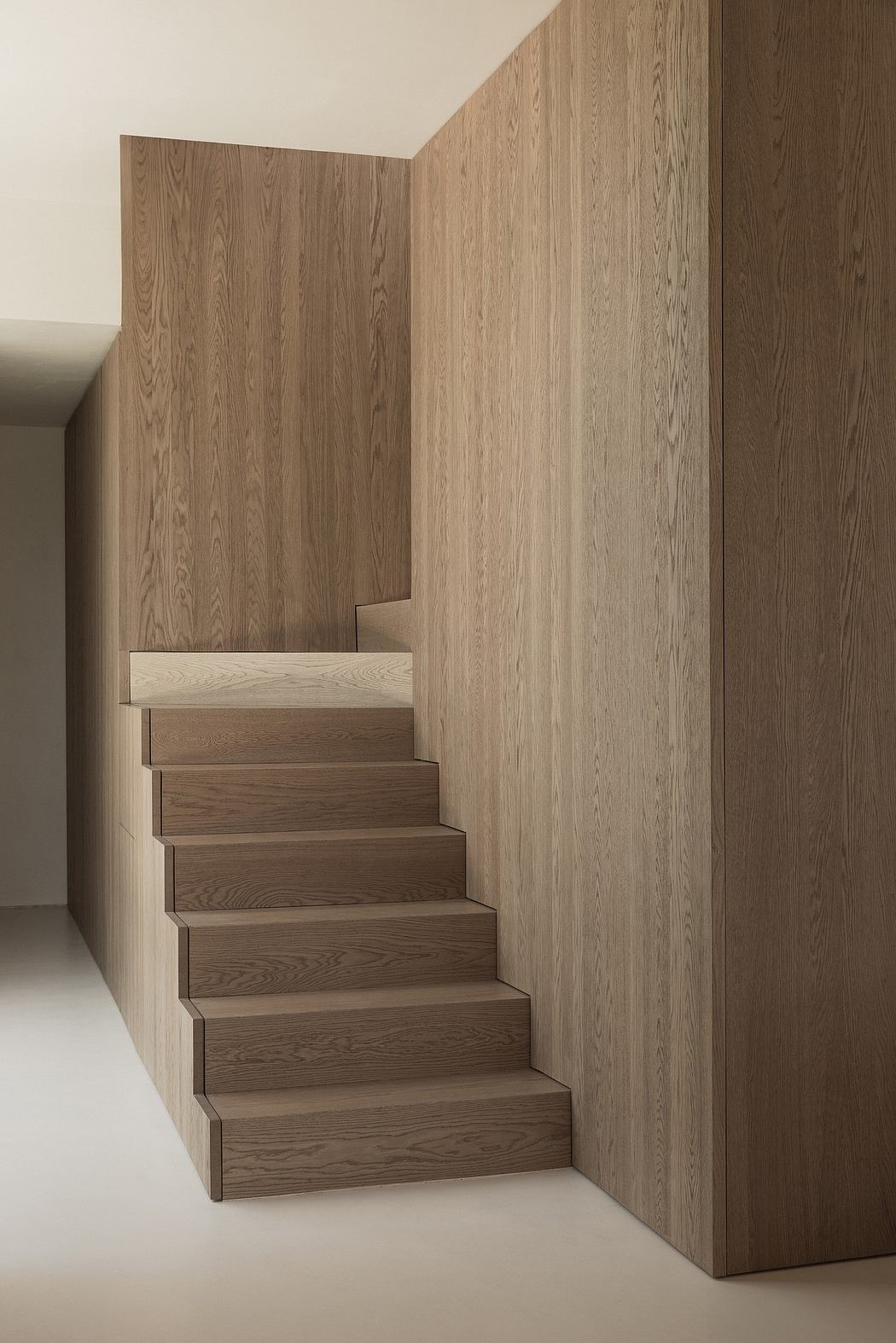 Minimalist staircase with rectilinear wooden paneling and floating treads.