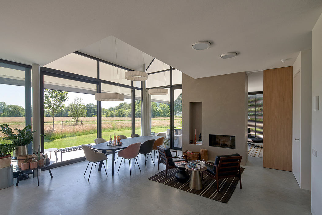 Modern, open-plan living space with large windows, concrete floors, and minimalist decor.