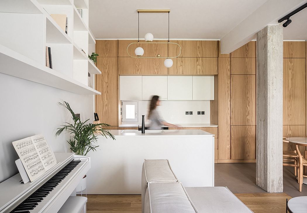 A modern and minimalist kitchen with wood paneling, white cabinetry, and pendant lighting.