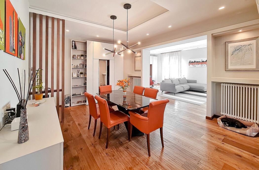 Stylish open-concept living area with wooden floors, modern lighting, and vibrant orange accents.