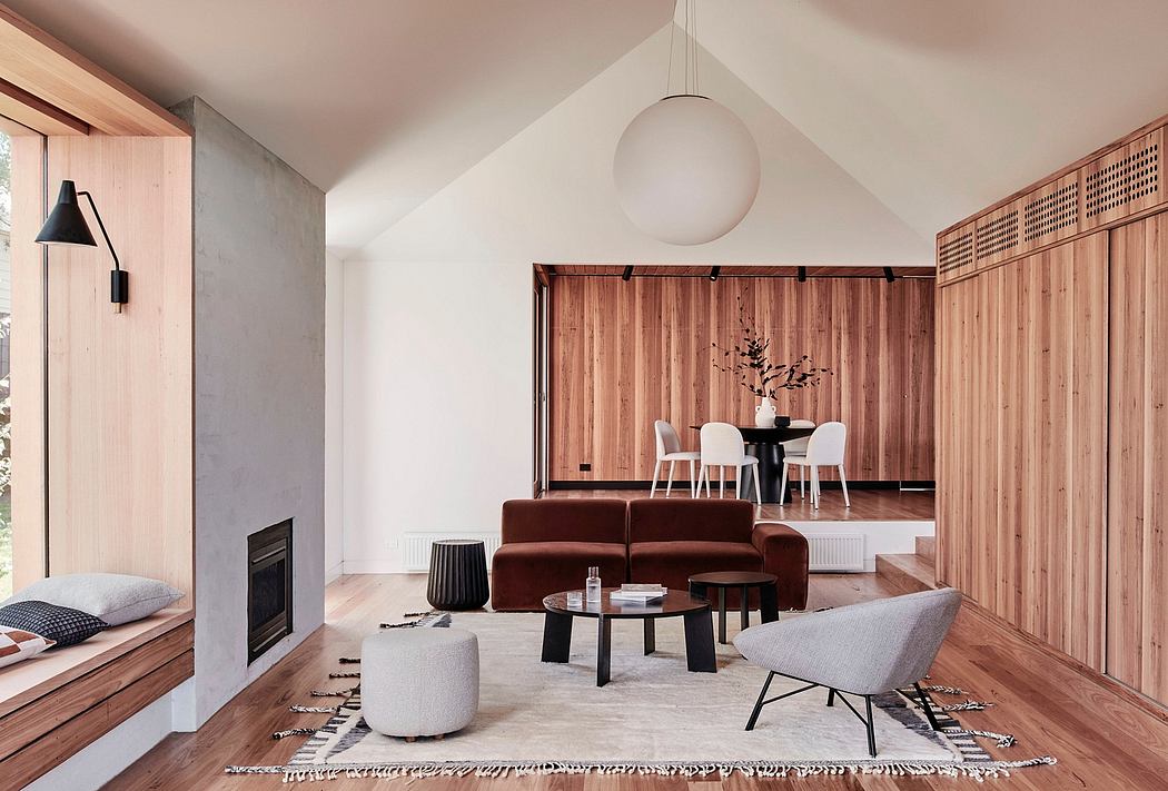 Cozy, modern living room with warm wood paneling, plush sofa, and globe pendant light.