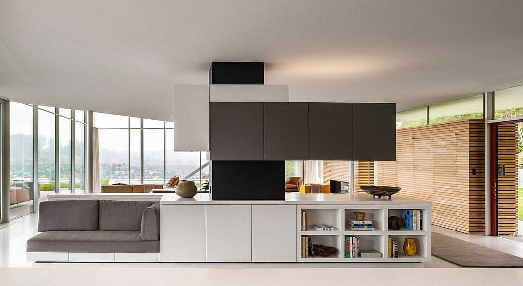 Sleek, minimalist open-concept living space with floor-to-ceiling windows, monochrome cabinetry, and a cozy sofa.