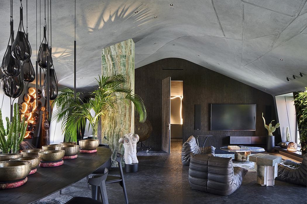 Striking modern interior with concrete walls, lush greenery, and striking light fixtures.