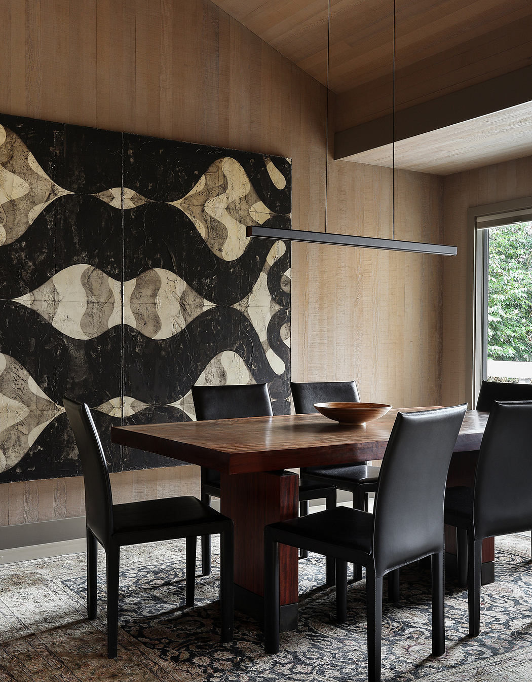 Sleek, modern dining room with a striking marble feature wall and hanging light fixture.