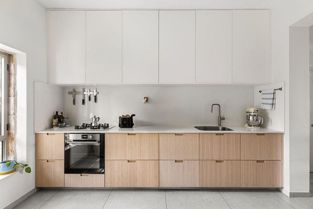 Minimalist kitchen with light-colored wood cabinets, sleek appliances, and a neutral color scheme.