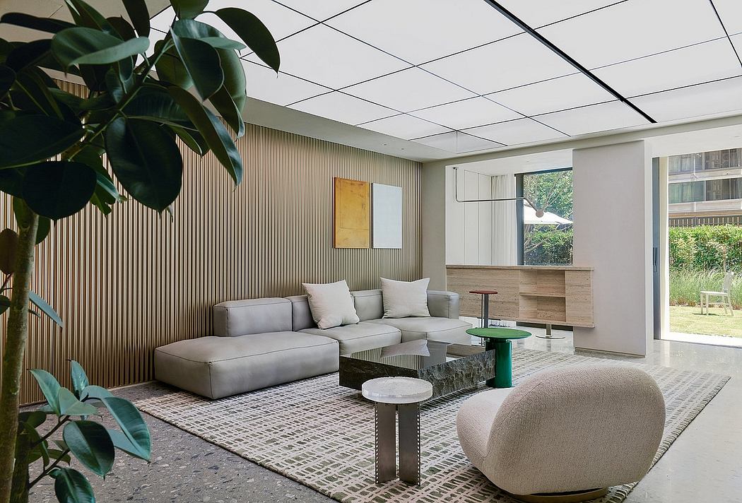 Sleek, modern living room with wood paneling, plush gray sofa, and geometric stone tables.