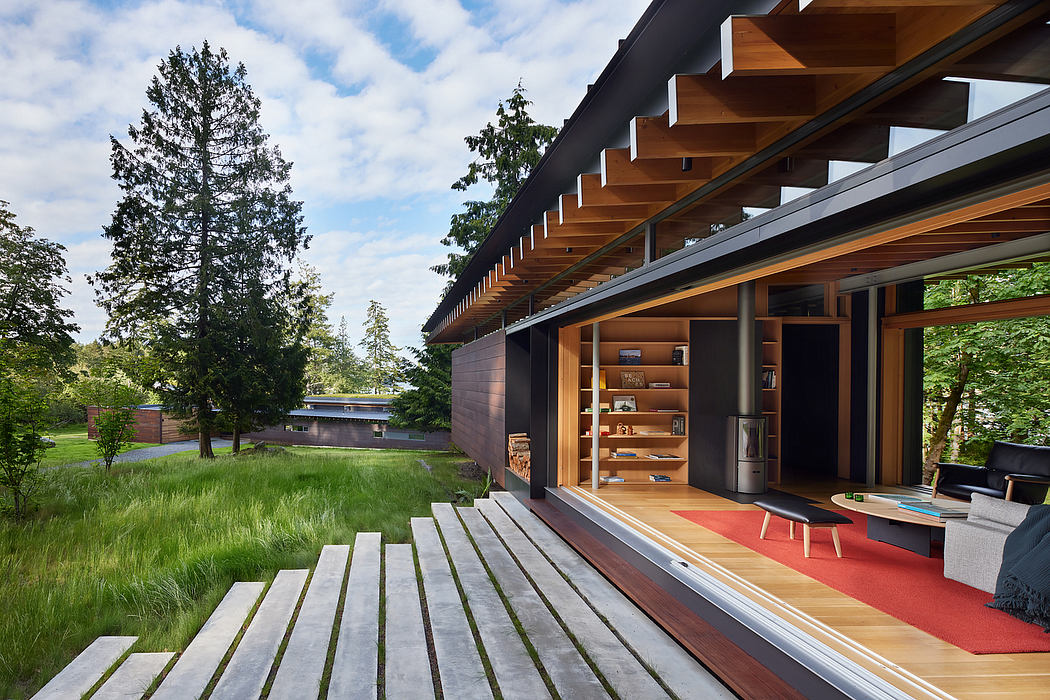 A modern, open-concept home with a large deck overlooking a grassy yard and trees.