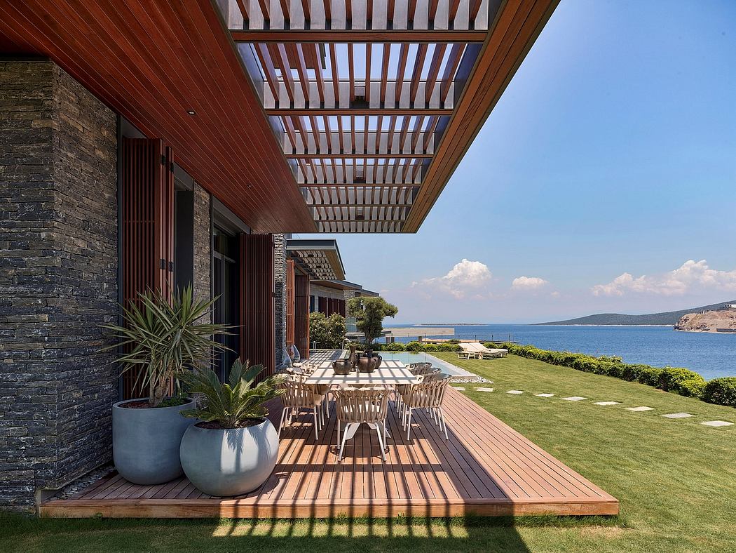 A modern architectural design featuring a wooden deck, stone walls, and panoramic ocean views.