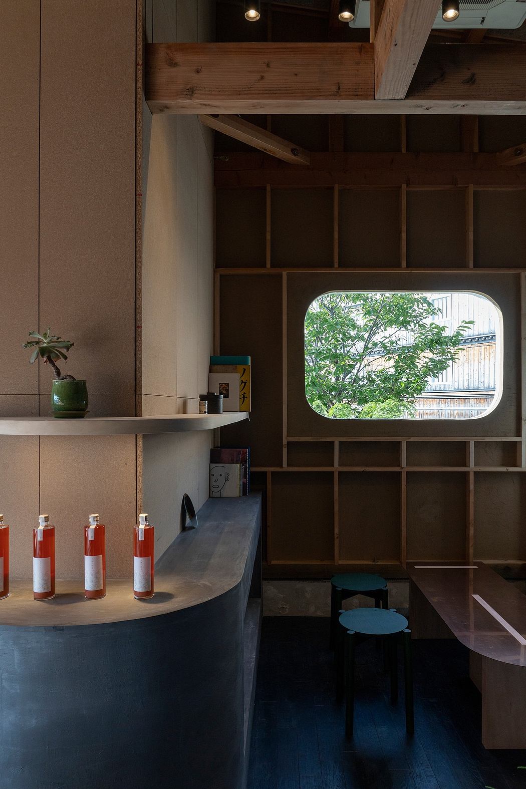 Cozy wooden interior with a panoramic window showcasing lush greenery outside.