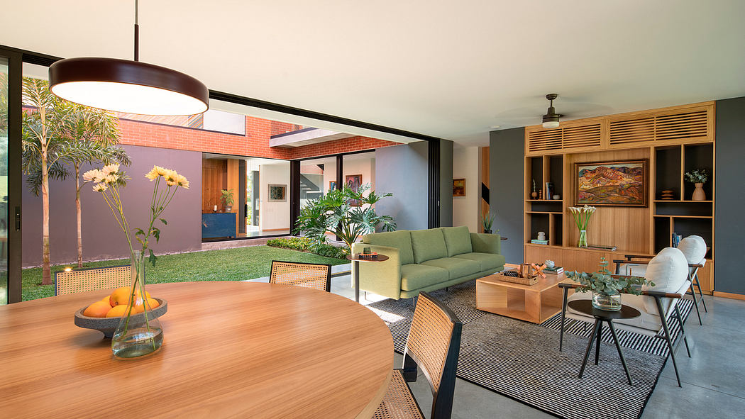 A modern, open-concept living space with wooden furnishings, greenery, and a striking light fixture.