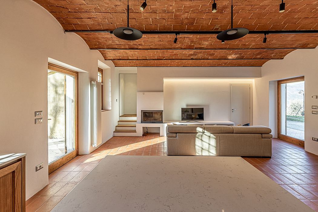 Expansive living space with exposed brick ceiling, wood beams, and large windows.