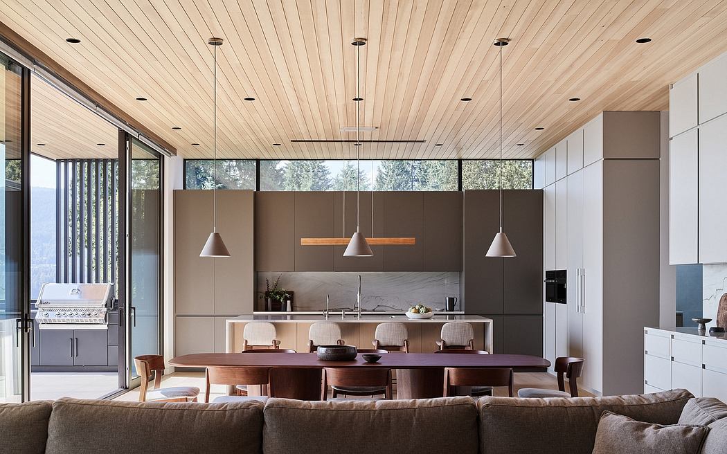 Spacious open-concept kitchen with wooden beamed ceiling, large windows, and modern furnishings.