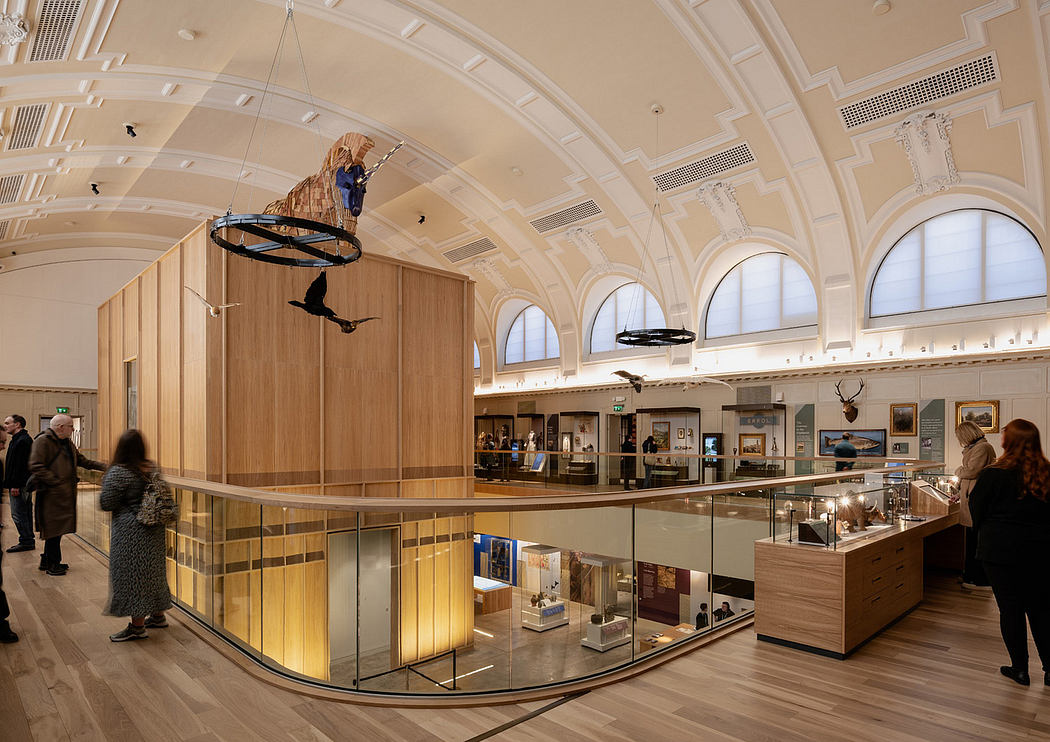 A grand, ornate lobby with arched windows, wooden accents, and suspended displays.