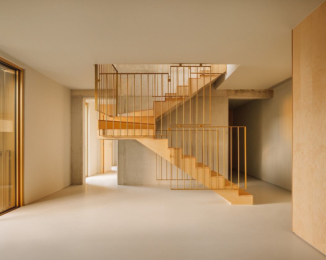 A modern staircase with intricate metal railings dominates the open, minimalist interior.
