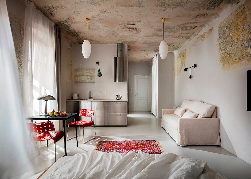 Rustic, open-concept studio with exposed concrete ceiling, modern furnishings, and patterned rug.