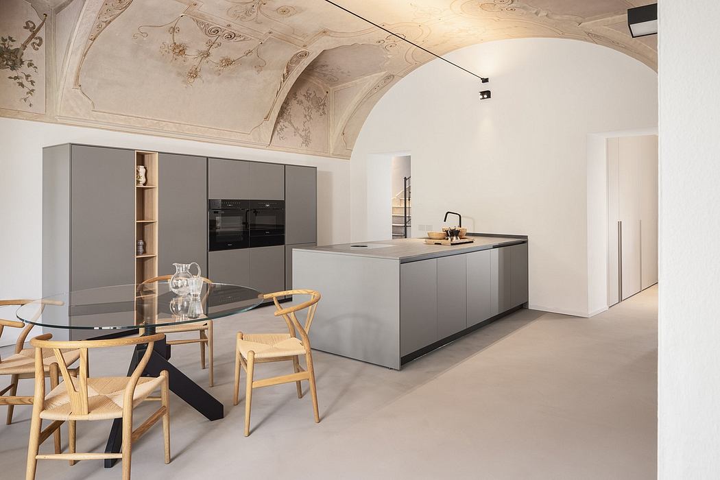 A spacious, architecturally stunning kitchen with ornate ceiling frescoes and modern, minimalist furniture.