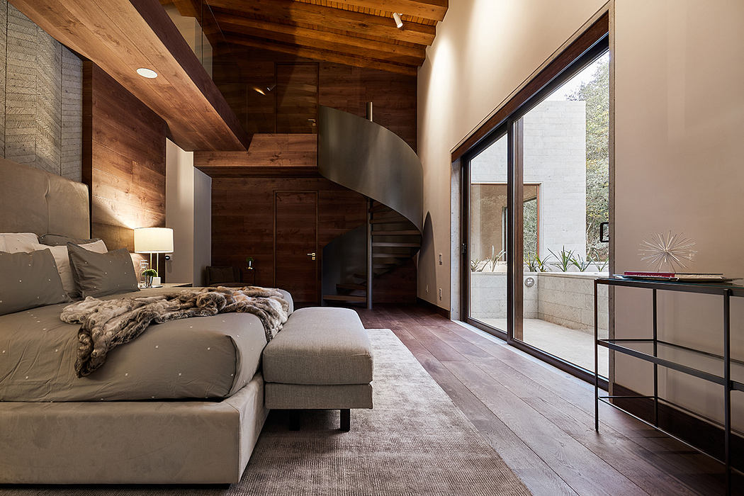 Rustic bedroom with wood-beamed ceiling, spiral staircase, and panoramic glass wall.